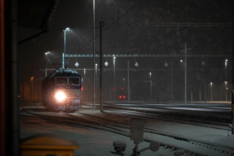 a train traveling on a track at night with it's headlights shining in the dark