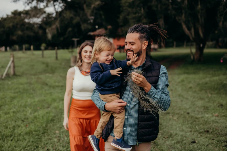 an image of man with children on his shoulders and mama holding him