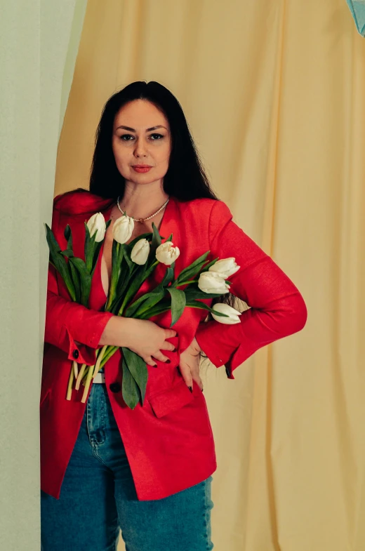 a woman in red jacket holding a bouquet of white tulips