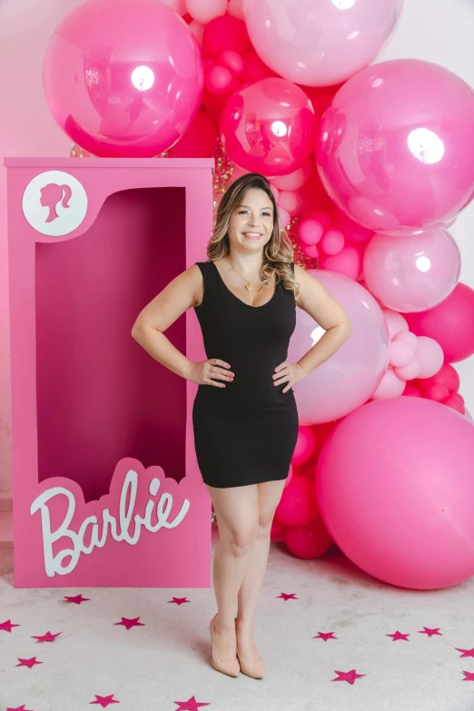 an attractive woman stands in front of some balloons