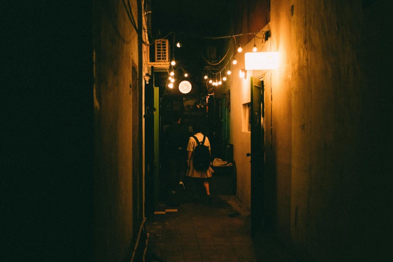 a person standing by the wall at night on the street