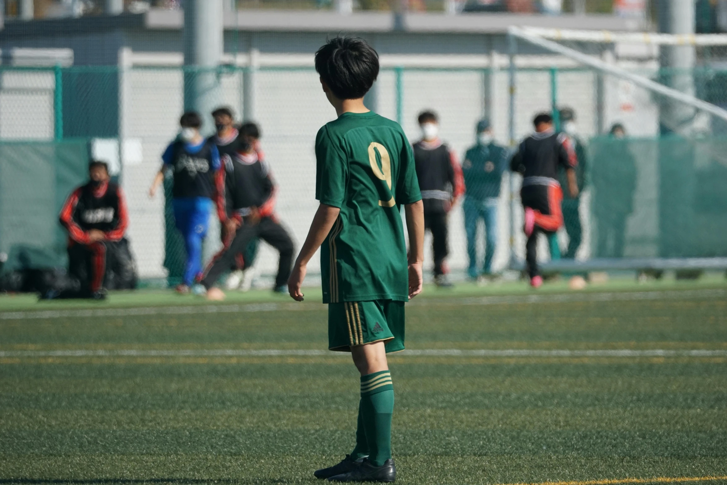 a young soccer player standing on the field