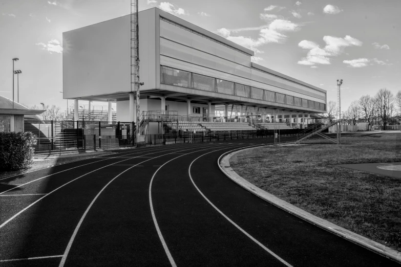 black and white po of tracks in front of a building