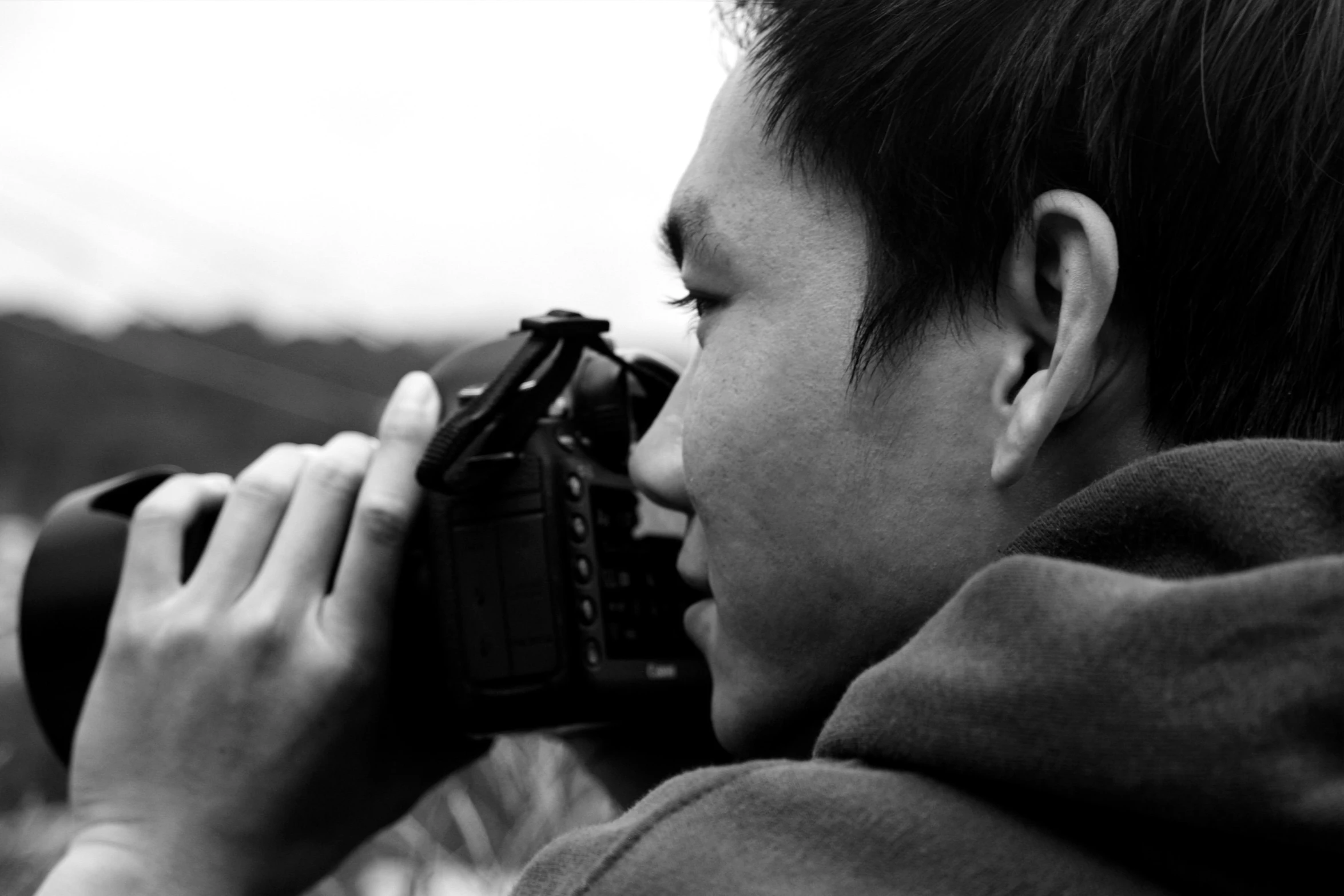 a boy looking through the lens of a camera