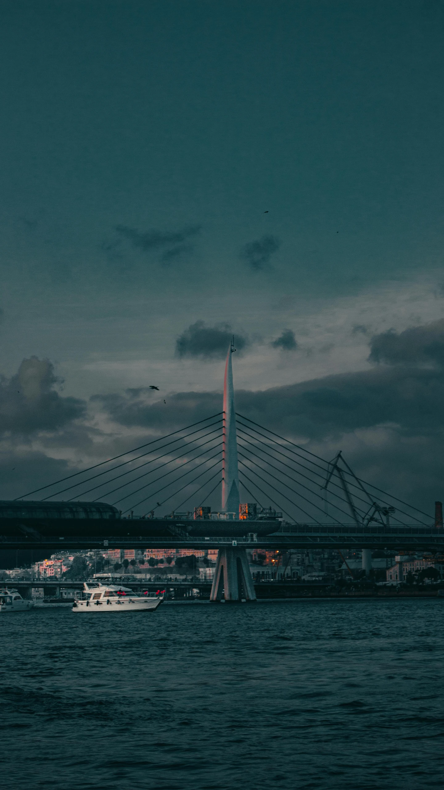 a boat in the water in a harbor with a bridge in the background