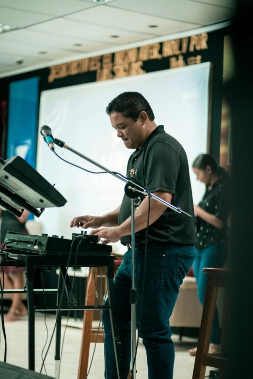 a man is performing on his keyboard in front of a microphone