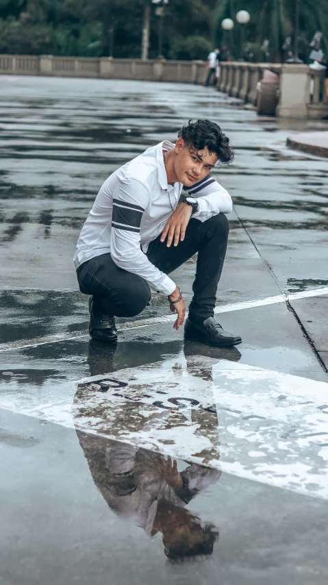 a man kneeling in water with his reflection