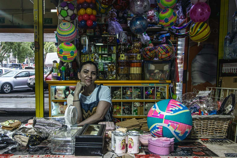 a woman stands in front of her display of colorful items