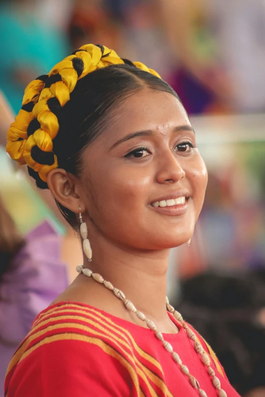 a woman wearing yellow beads smiles for the camera