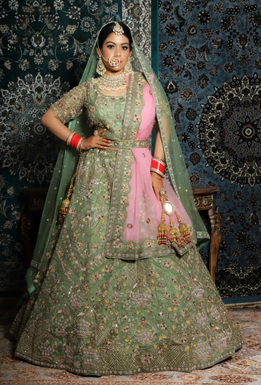 an indian bride in an ornately designed green gown