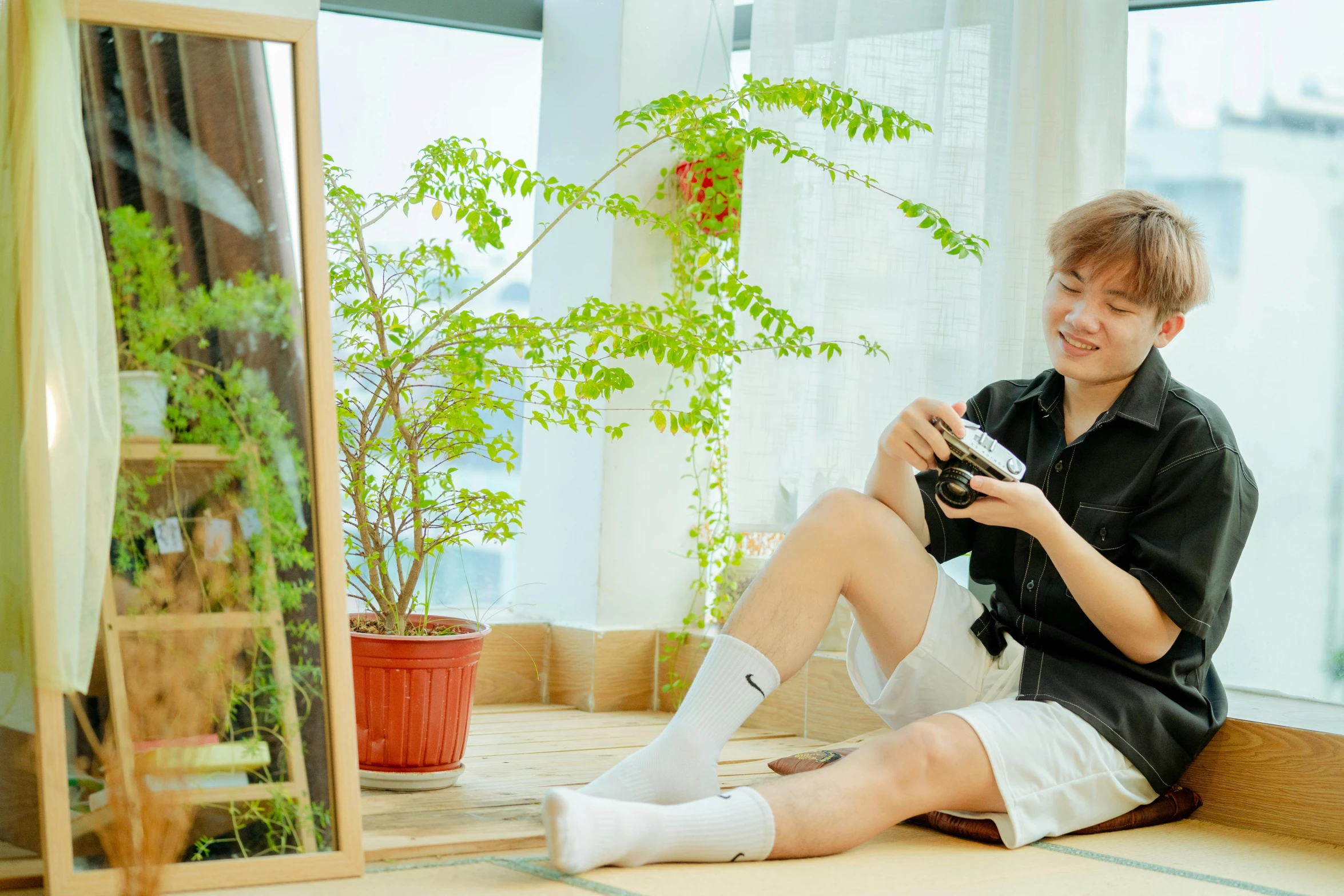 a boy sitting on the floor looking at his camera