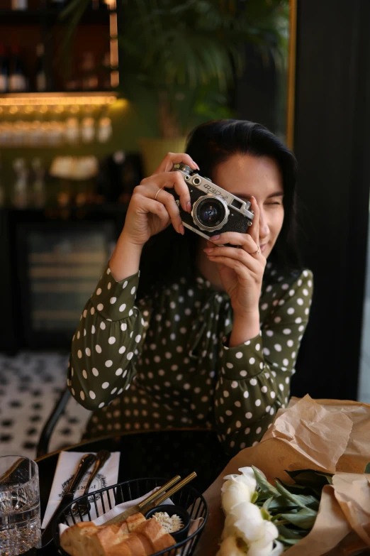 woman holding up a camera taking a picture of food