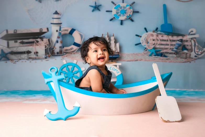 an adorable toddler in a boat made to look like a boat