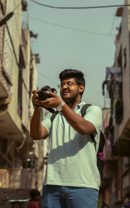 a man stands in an alley holding a digital camera