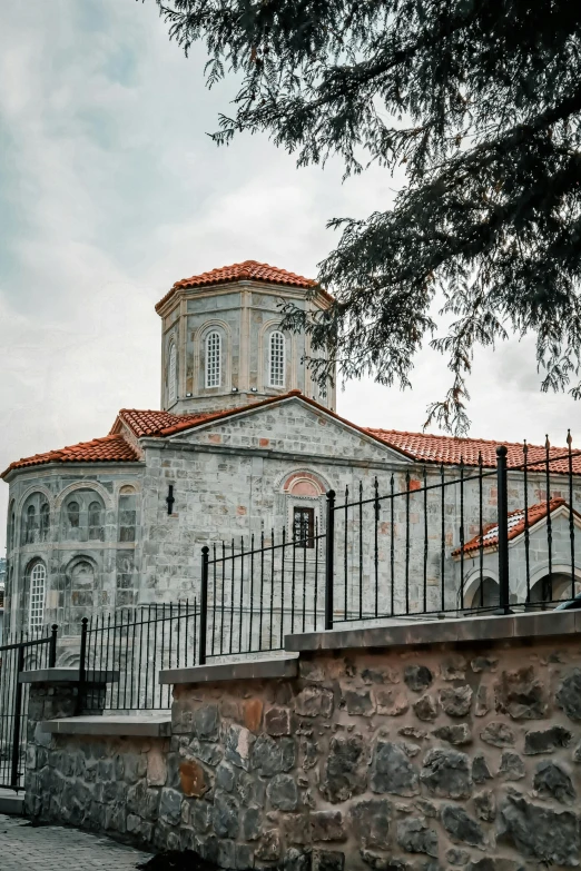 an old church stands next to a very long fence