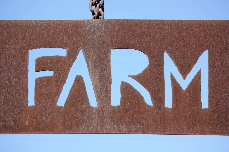 a rusted sign with words that read farm