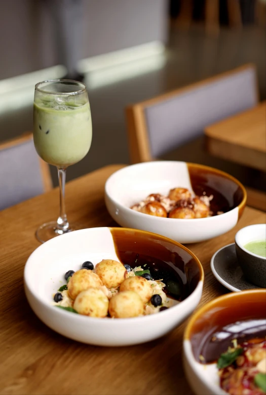 small bowls of various food items and a wine glass