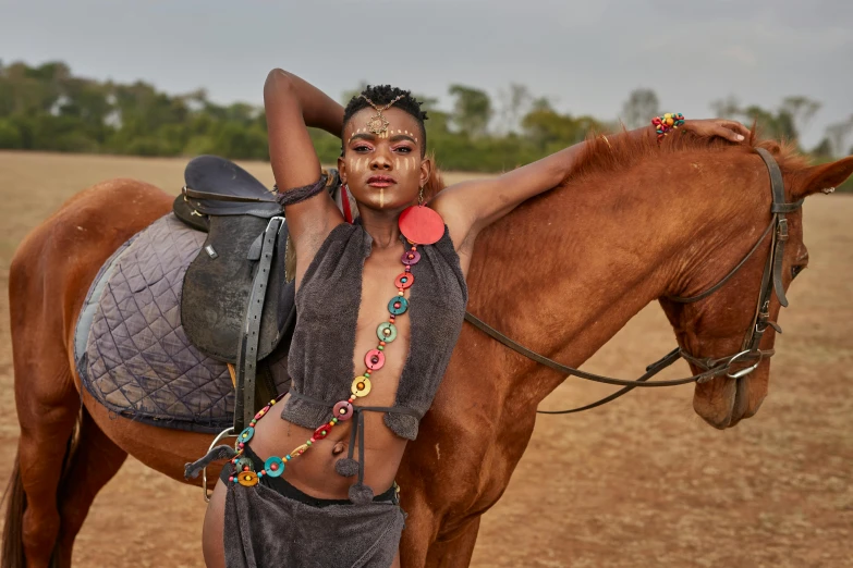 a man poses next to a horse with colorful beads on it