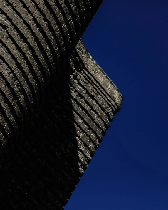 a airplane flying high in the sky near a large rock