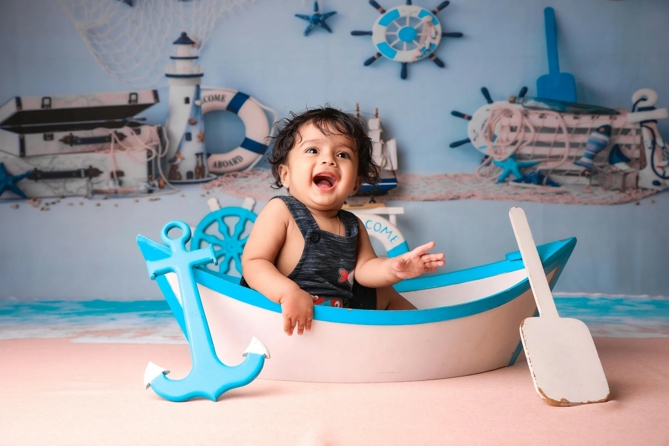 the baby girl smiles while sitting in the boat