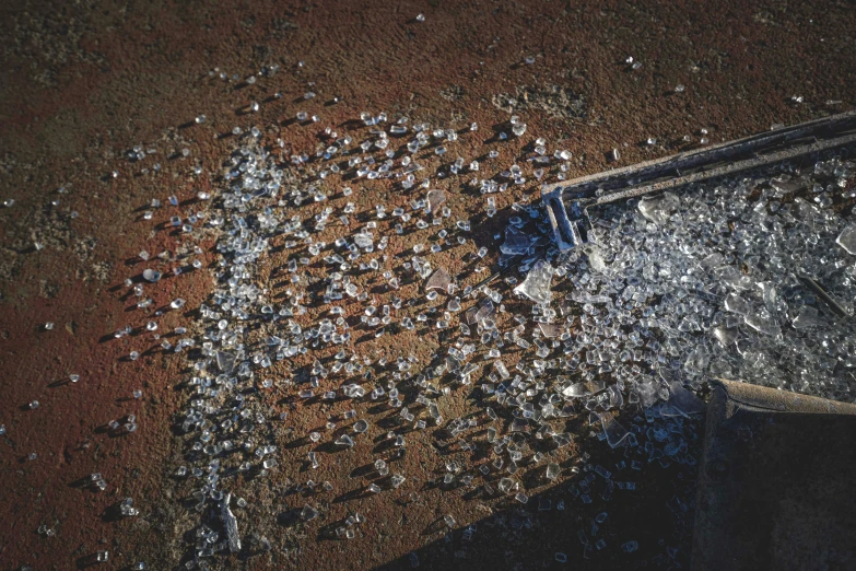 a muddy field with a pair of boots near water and rocks