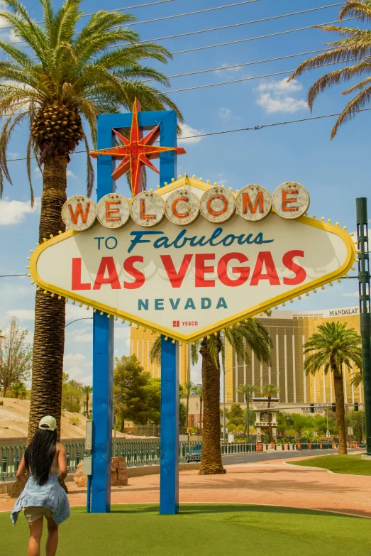 woman walking toward las vegas welcome to fabulous las vegas sign