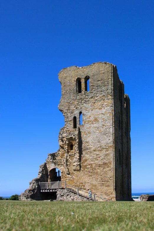 an old ruins stands in the grass on a sunny day