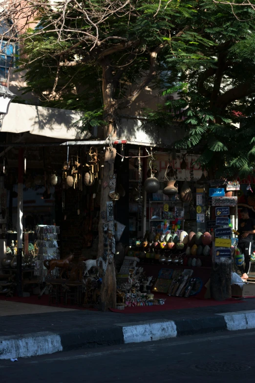 the corner of a street that has a store with lots of stuff on display