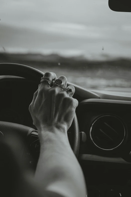 the interior of a car being driven by a hand on a steering wheel