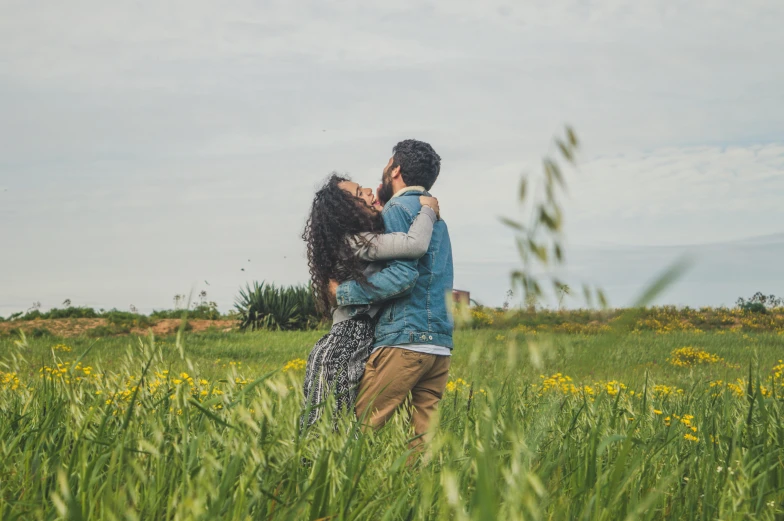 two people kissing in the grass and flowers