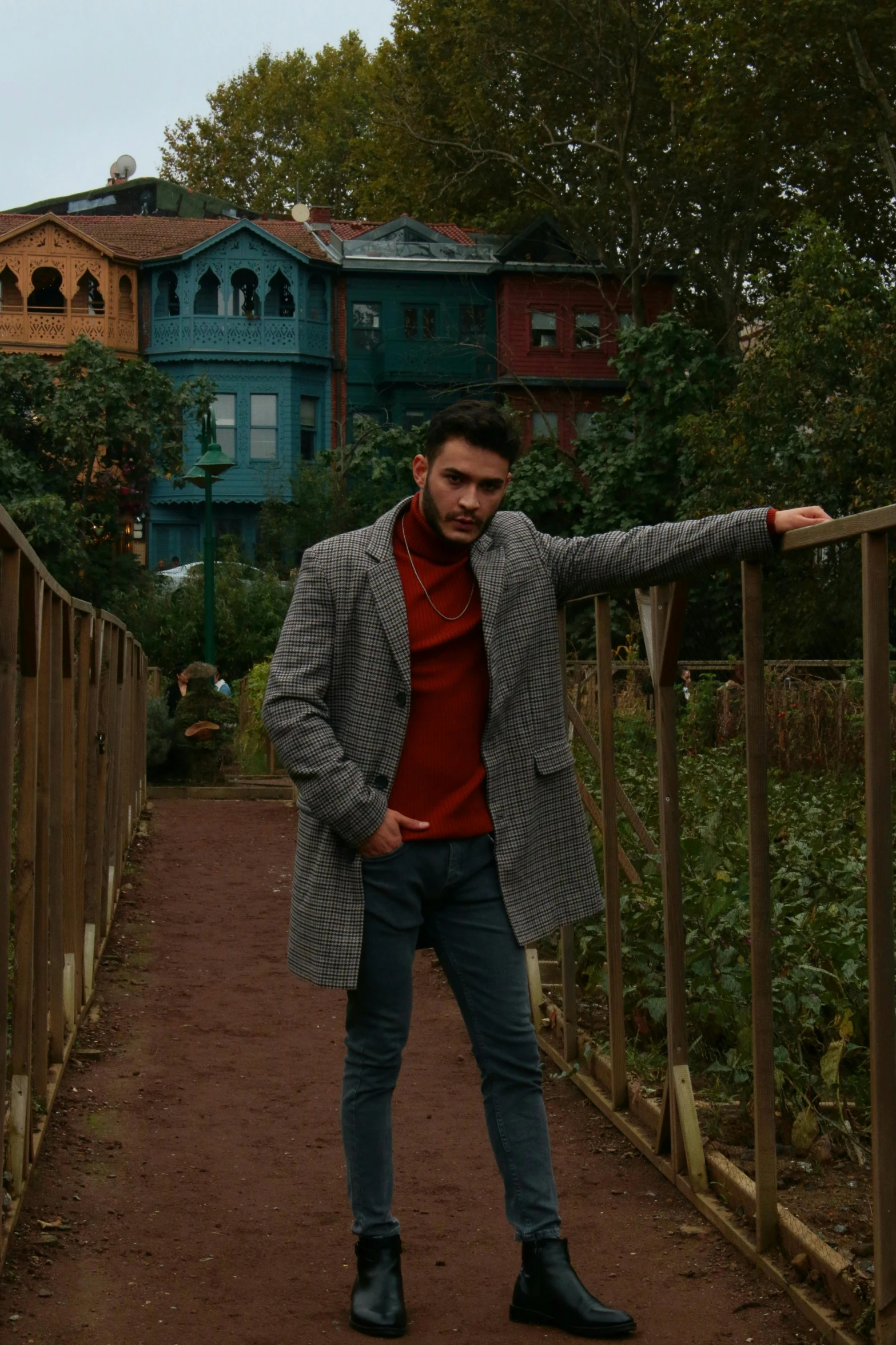 a man in a suit stands at the end of a bridge