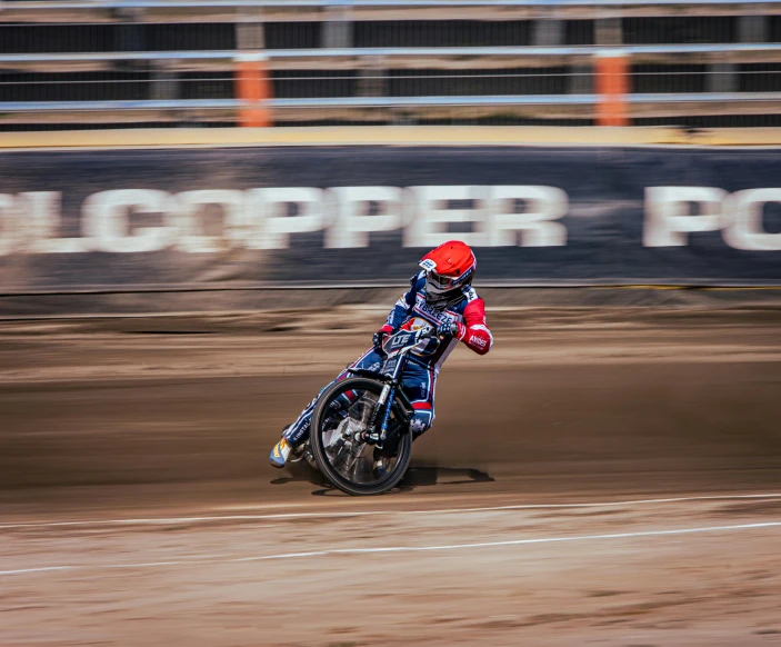 a motorcyclist going fast on a dirt track