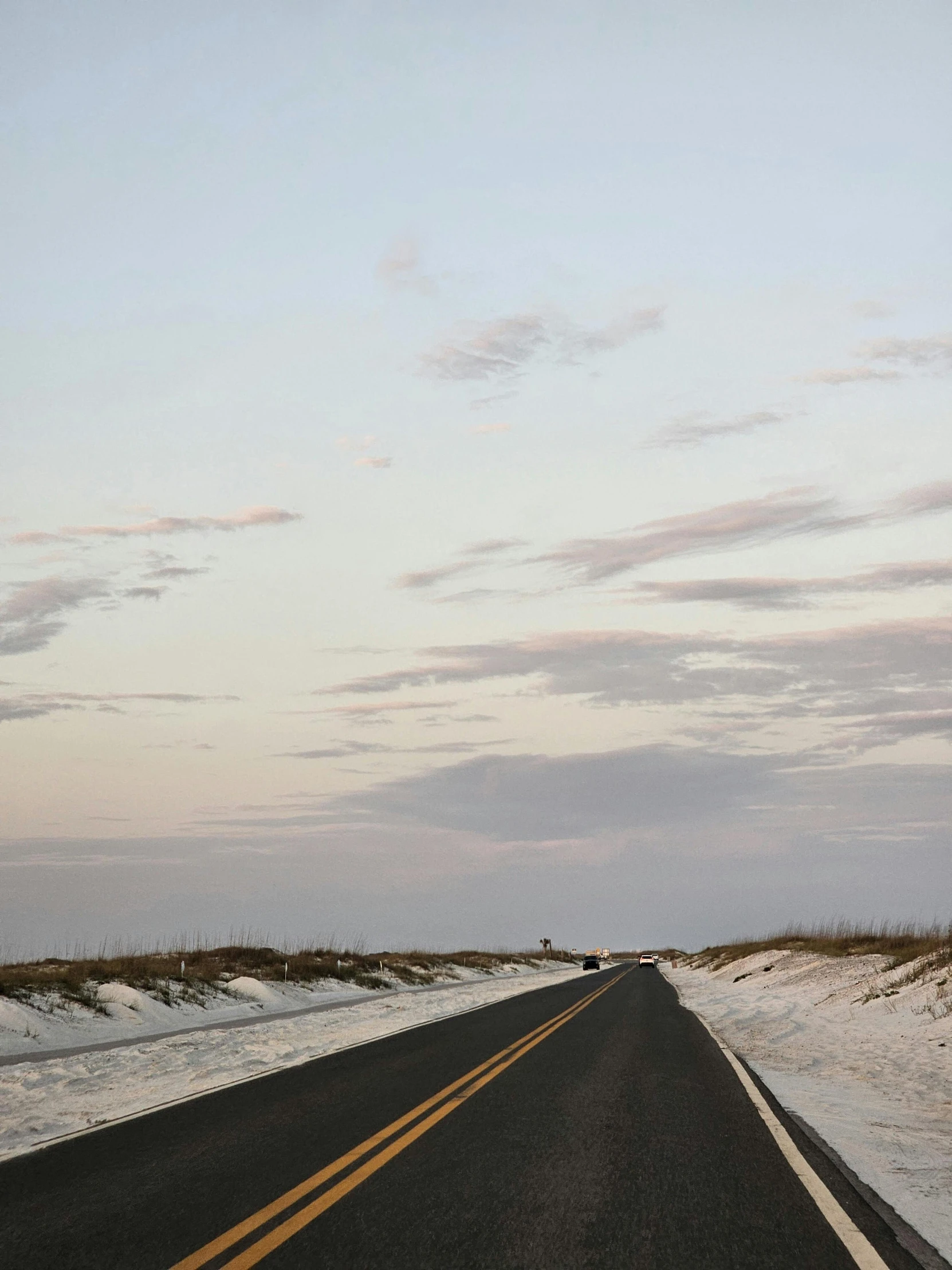 an empty highway that looks very deserted with white snow