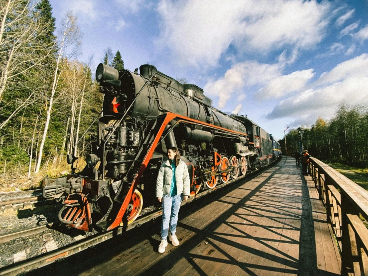 a person standing on the train tracks by the engine