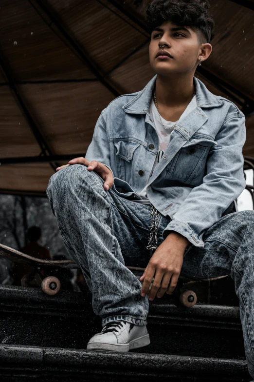 a young man is sitting on some steps with a skateboard