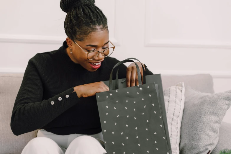 a lady in black holding a bag on her lap