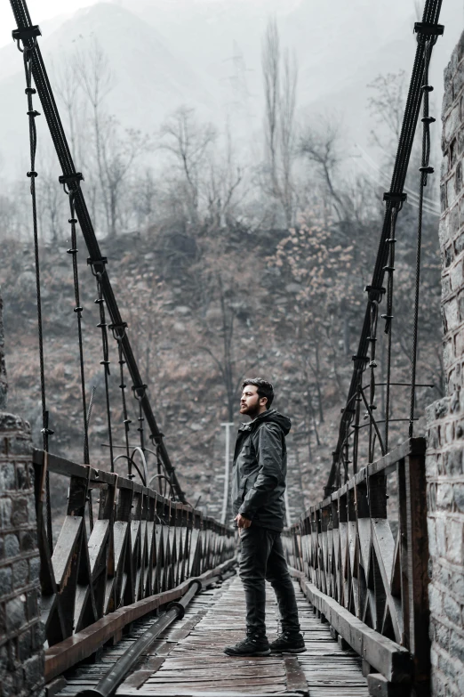 man standing on a bridge while foggy day ends