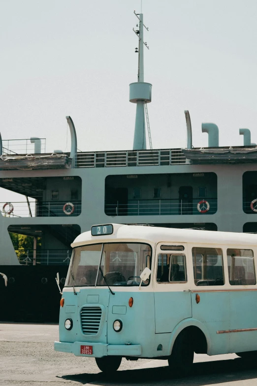 a blue and white bus driving past a building