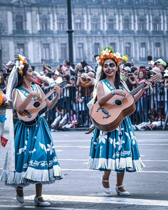 two women dressed in traditional clothing are playing guitars