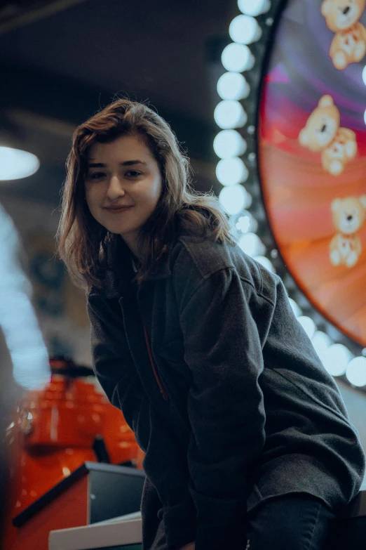 a young asian woman leans against a carousel wheel