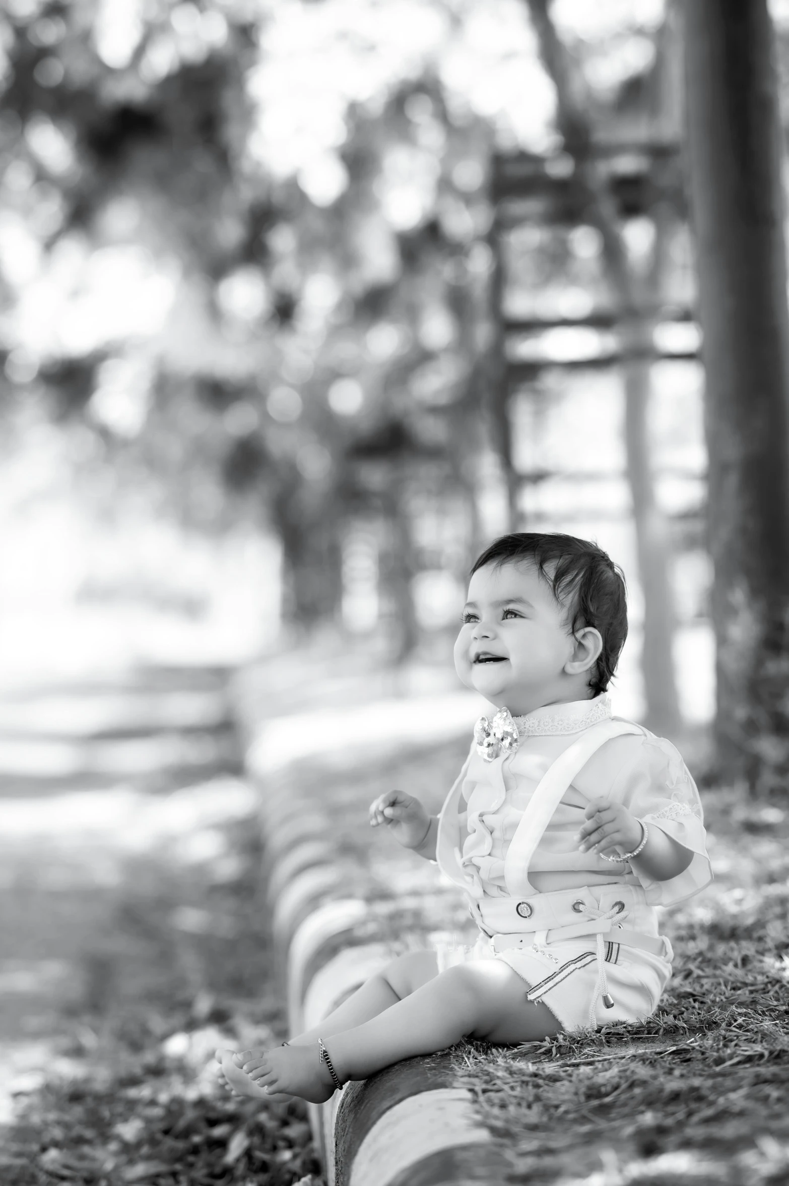 a baby sits on a bench in the park