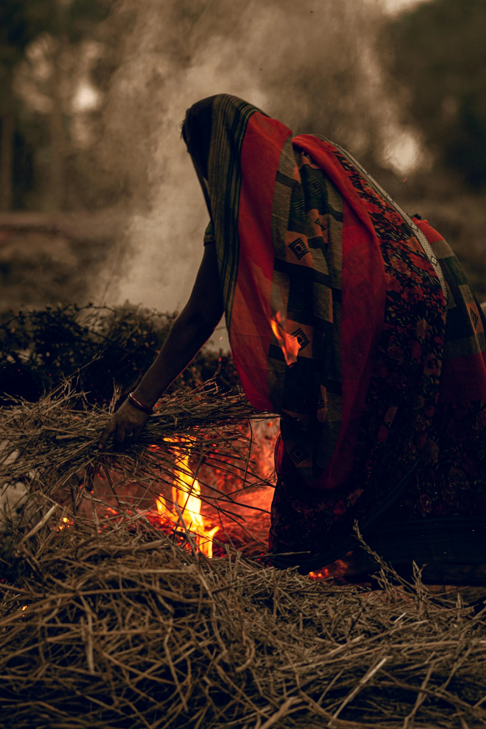 an old po shows a person wrapped in fabric near fire