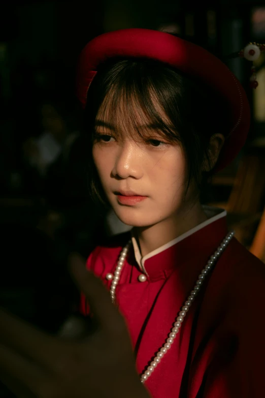 a young woman wearing red standing in front of a black background