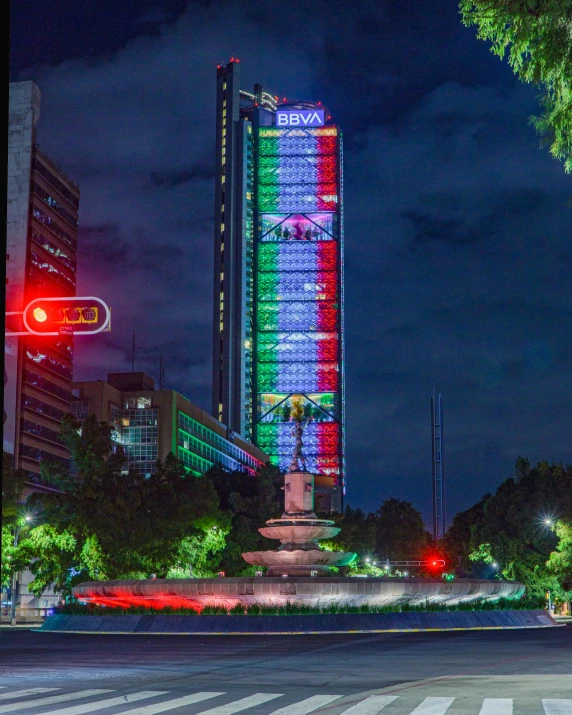 a big building with lights on in front of a crosswalk