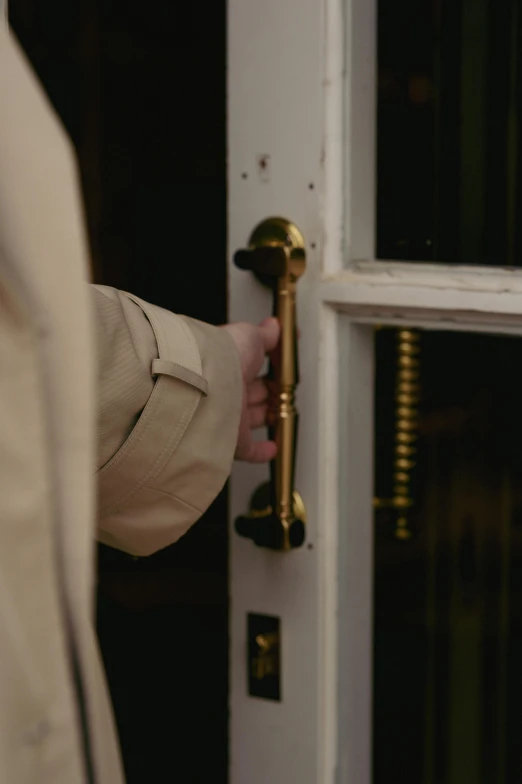 a person is holding the door handle with his left hand