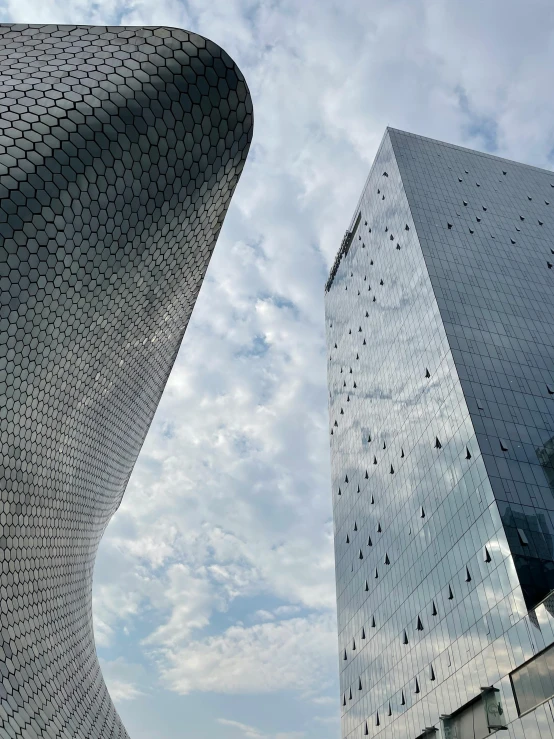 two buildings with metal lattice designs in front of them