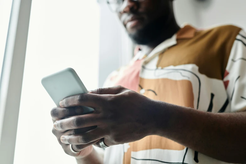 a man is holding a white phone in his hand