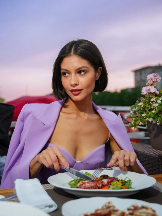 the woman is holding a knife and fork as she prepares to eat