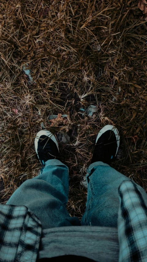 the person with the sneakers is standing on the grass