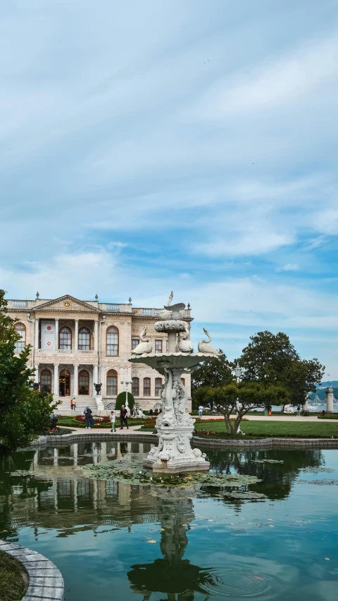 a fountain in front of a very large house